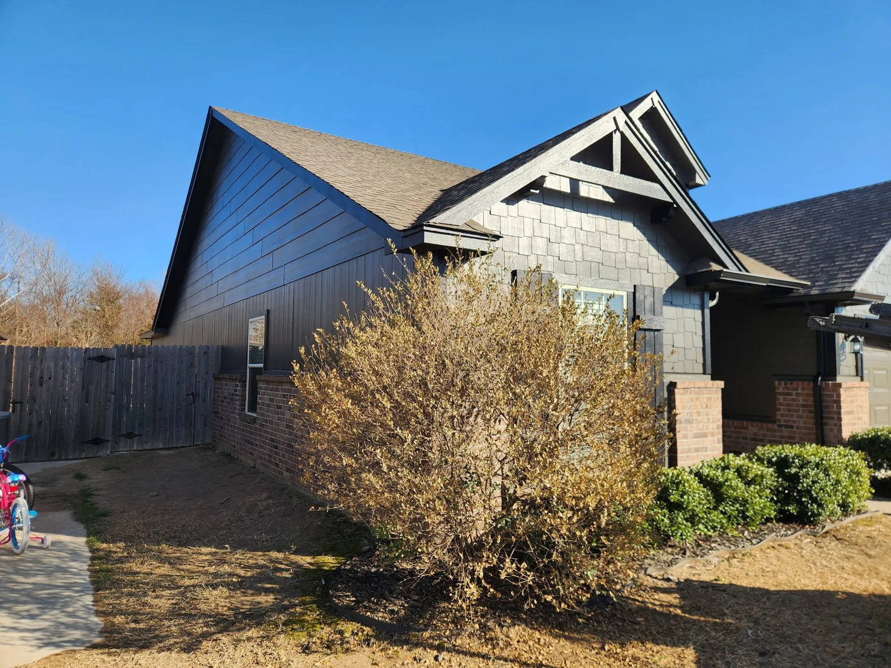 Dark gray siding with white trim after a full exterior repaint of an Owasso home